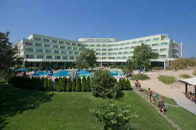 a group of people walking around a park with a building at Jeravi Club Hotel - All Inclusive in Primorsko