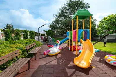 a playground with slides and play equipment in a park at Jeravi Club Hotel - All Inclusive in Primorsko