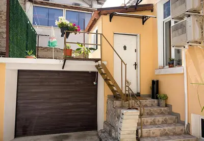 a garage with a black garage door and stairs at Central Studios on Maria Luiza Street - Cozy Stay in Varna by Flat Mаnаger in Varna City