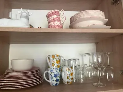 a shelf with plates and cups and dishes on it at Flat in Cascadas 21 in Sunny Beach