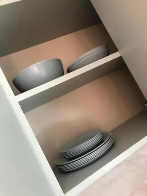 a shelf with a bunch of plates in a cabinet at Първа Линия Лазур Поморие in Pomorie