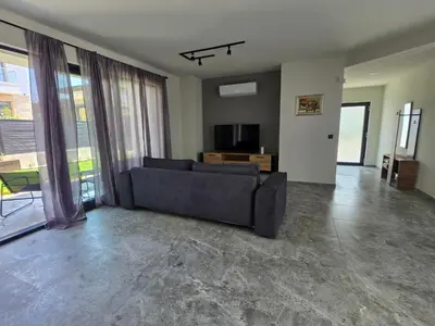 a living room with a couch and a tv at Villa Cadaques, private pool with heating and salt water in Lozenets