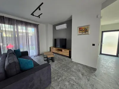 a living room with a couch and a tv at Villa Cadaques, private pool with heating and salt water in Lozenets