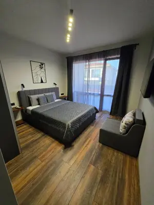 a bedroom with a bed and a chair and a window at Villa Cadaques, private pool with heating and salt water in Lozenets