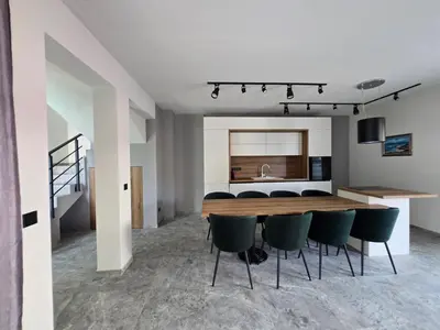 a dining room with a table and green chairs at Villa Cadaques, private pool with heating and salt water in Lozenets