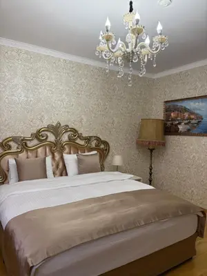 a bedroom with a large bed with a chandelier at Hogo Fogo in Burgas City