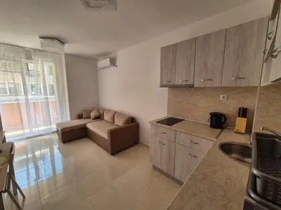 a kitchen and living room with a couch in a room at Комфортен Апартамент Лазур in Pomorie