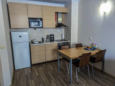 a kitchen with a table and a white refrigerator at Obzor Beach Resort F001 Urlaub BG in Obzor