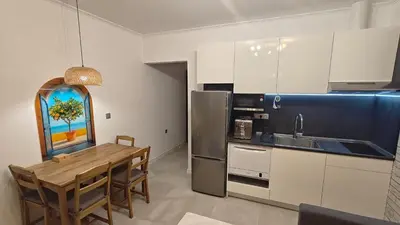 a kitchen with a wooden table and a refrigerator at Vivid Sea and City Luxury Studio 2 plus 2 in Burgas City