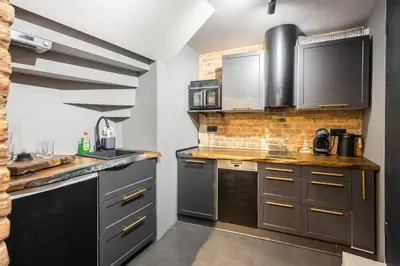 a kitchen with stainless steel appliances and a brick wall at Skyler 9 in Varna City