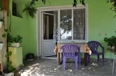 a room with purple chairs and a table and a window at Rooms Ivanka Ground Floor in Obzor