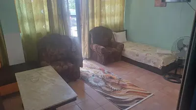 a living room with two chairs and a table at Rooms Ivanka Ground Floor in Obzor