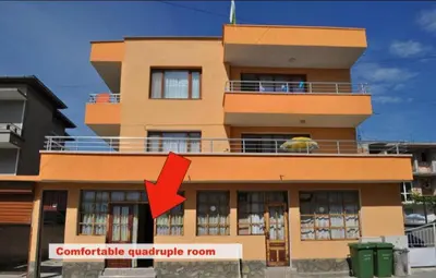 a building with a red arrow in front of it at Rooms Ivanka Ground Floor in Obzor