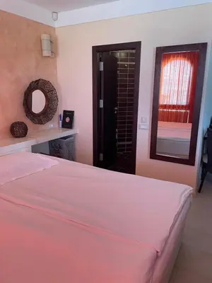 a bedroom with a bed and a mirror and a window at Beachfront Apartment Oasis VIP Club in Sunny Beach