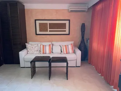 a living room with a white couch and a guitar at Beachfront Apartment Oasis VIP Club in Sunny Beach