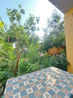 a tiled table with a garden in the background at Family Hotel California in Primorsko