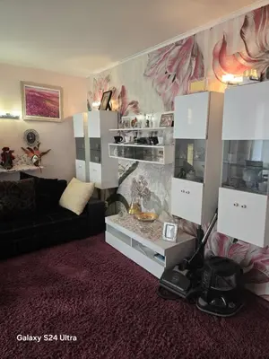 a living room with a black couch and white cabinets at Несебър Златна Дюна in Nesebar