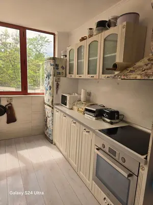 a kitchen with white cabinets and a stove top oven at Несебър Златна Дюна in Nesebar