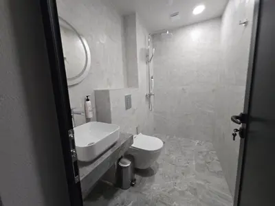 a bathroom with a sink and a toilet and a mirror at villa Amethyst, private pool with heating and salt water in Lozenets