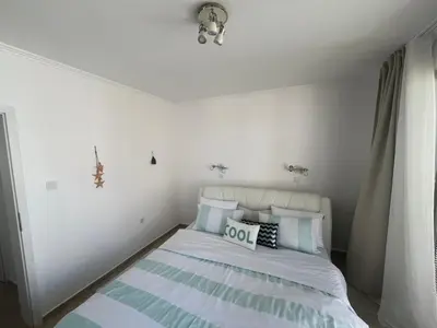 a bedroom with a bed with blue and white pillows at Private apartment in complex Diamond in Sveti Vlas