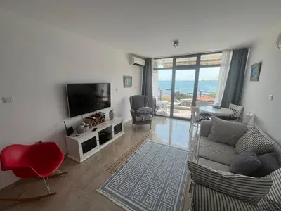 a living room with a couch and a flat screen tv at Private apartment in complex Diamond in Sveti Vlas