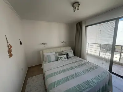 a bedroom with a bed and a large window at Private apartment in complex Diamond in Sveti Vlas