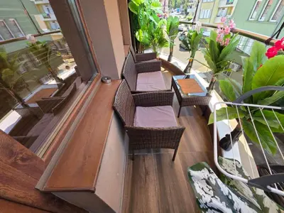 a balcony with chairs and tables and potted plants at DN Kiten in Kiten