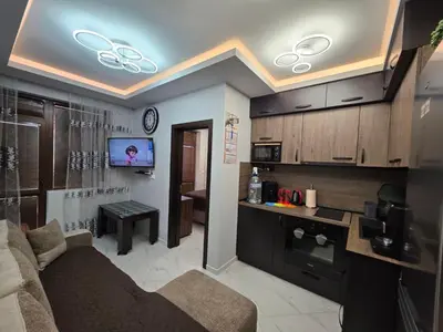 a living room with a couch and a tv on the ceiling at DN Kiten in Kiten