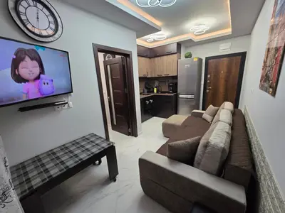a living room with a couch and a tv on a wall at DN Kiten in Kiten
