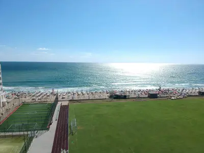 a beach with a crowd of people and the ocean at Sunny Island Obzor in Obzor
