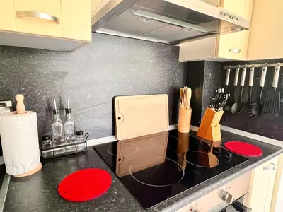 a kitchen with a black counter top with red plates at Velika Garden Villas 1 bedroom apartment, Lozenets in Lozenets