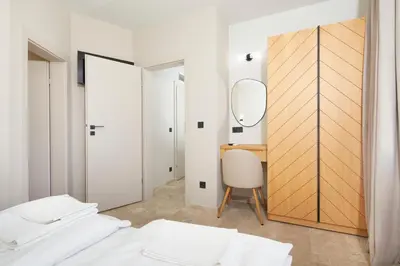 a bedroom with a mirror and a desk at Семеен хотел НОА in Nesebar