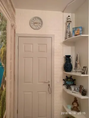 a white door in a room with a clock on the wall at Элитные апартаменты у моря in Lozenets