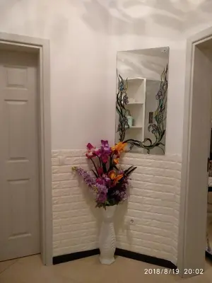 a vase with flowers in front of a mirror at Элитные апартаменты у моря in Lozenets