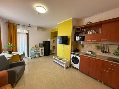 a living room with a couch and a kitchen at Palazzo SP apartments-Sunny Beach in Burgas City
