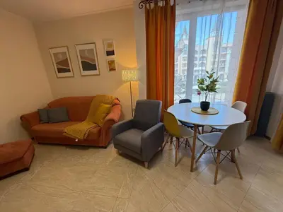 a living room with a couch and a table with chairs at Palazzo SP apartments-Sunny Beach in Burgas City