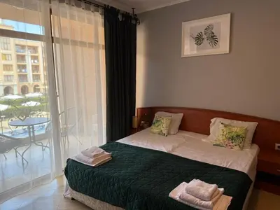 a bedroom with a bed and a large window at Palazzo SP apartments-Sunny Beach in Burgas City
