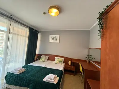 a bedroom with a bed and a desk and a window at Palazzo SP apartments-Sunny Beach in Burgas City