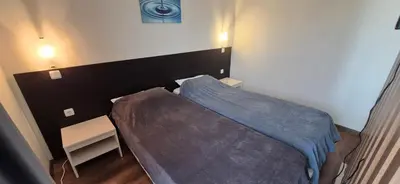 a small bedroom with a bed with a blue blanket at Apartment Sofia Macon Residence Sveti Vlas in Sveti Vlas