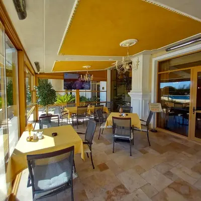 a dining room with yellow tables and chairs at Romantic Studio Florence in Sveti Vlas