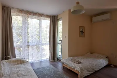 a bedroom with a bed and a large window at Green Corner Apartment in the Center - 2BD in Burgas City
