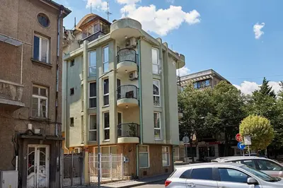 a tall building with cars parked in front of it at Green Corner Apartment in the Center - 2BD in Burgas City