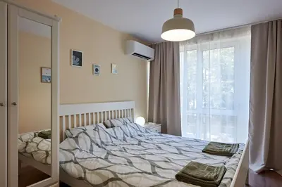 a bedroom with a bed and a large window at Green Corner Apartment in the Center - 2BD in Burgas City