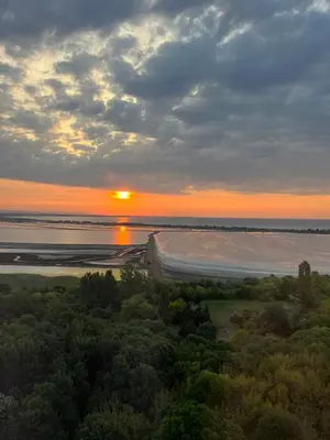 a sunset over the ocean with a boat in the water at Sky Sea Apartment in Burgas City