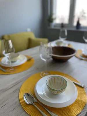 a wooden table with a plate and a bowl and glasses at Sky Sea Apartment in Burgas City
