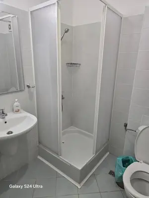 a bathroom with a shower with a sink and a toilet at Апартамент Хелиос Поморие in Pomorie