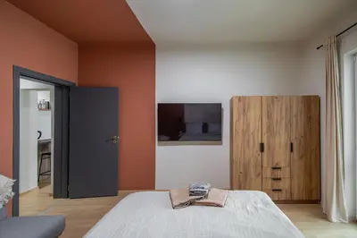 a bedroom with a bed and a wooden cabinet at City Center Gem Varna - 5 Guests in Varna City