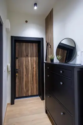 a bedroom with a wooden door and a dresser with a mirror at City Center Gem Varna - 5 Guests in Varna City