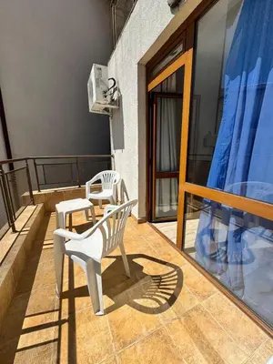 two white chairs sitting on a balcony at Трёхкомнатная квартира in Sveti Vlas