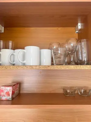 a shelf with cups and other glass items on it at Трёхкомнатная квартира in Sveti Vlas